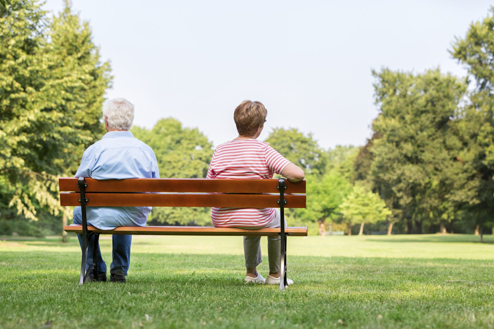 Senior couple on bench separated